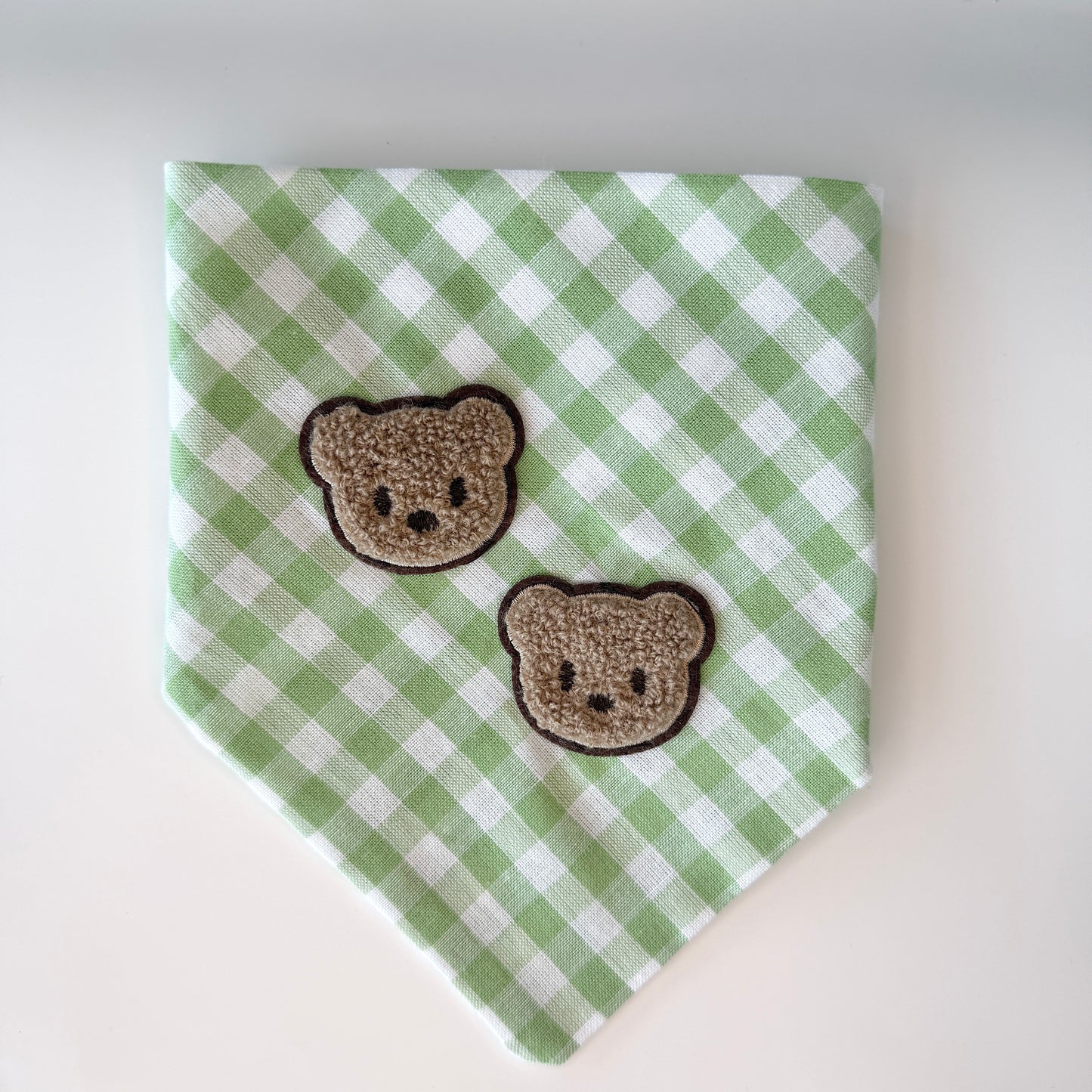 Green and white checkered bandana with two brown bear faces on a white background