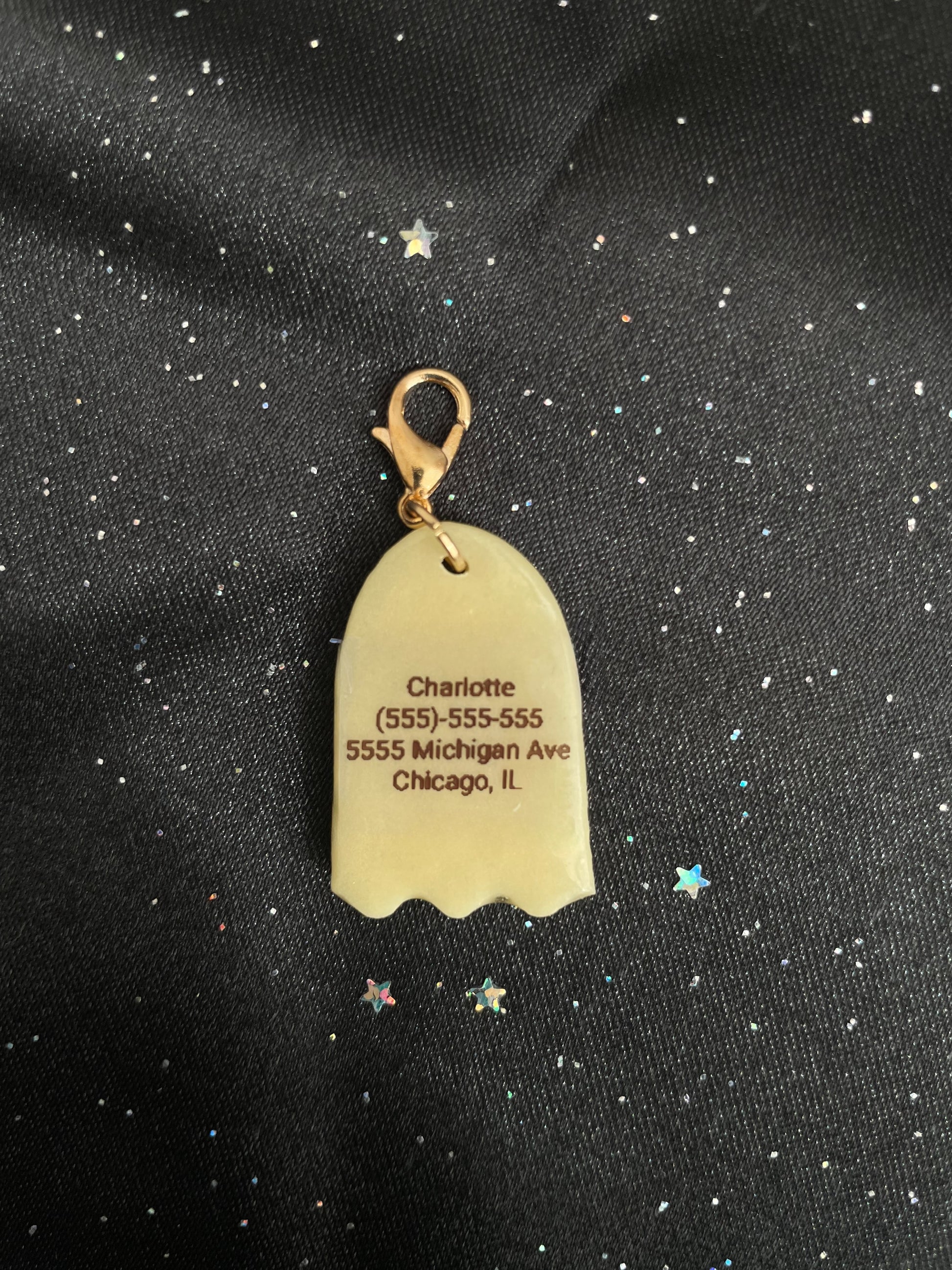 Gold tag with engraved text on a black fabric background