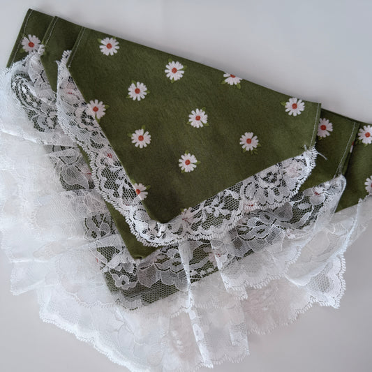 Green cotton over the collar bandanas with white floral patterns and lace trim on a light gray background