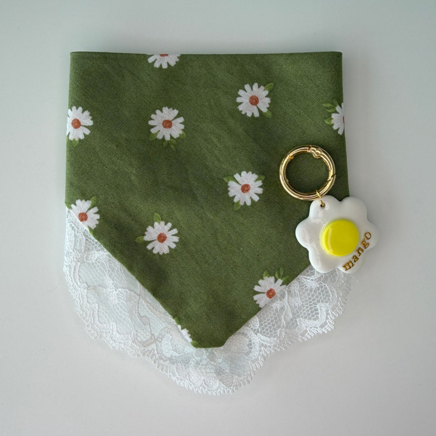 Green bandana with white daisy pattern and lace trim with a daisy matching id tag on a white background