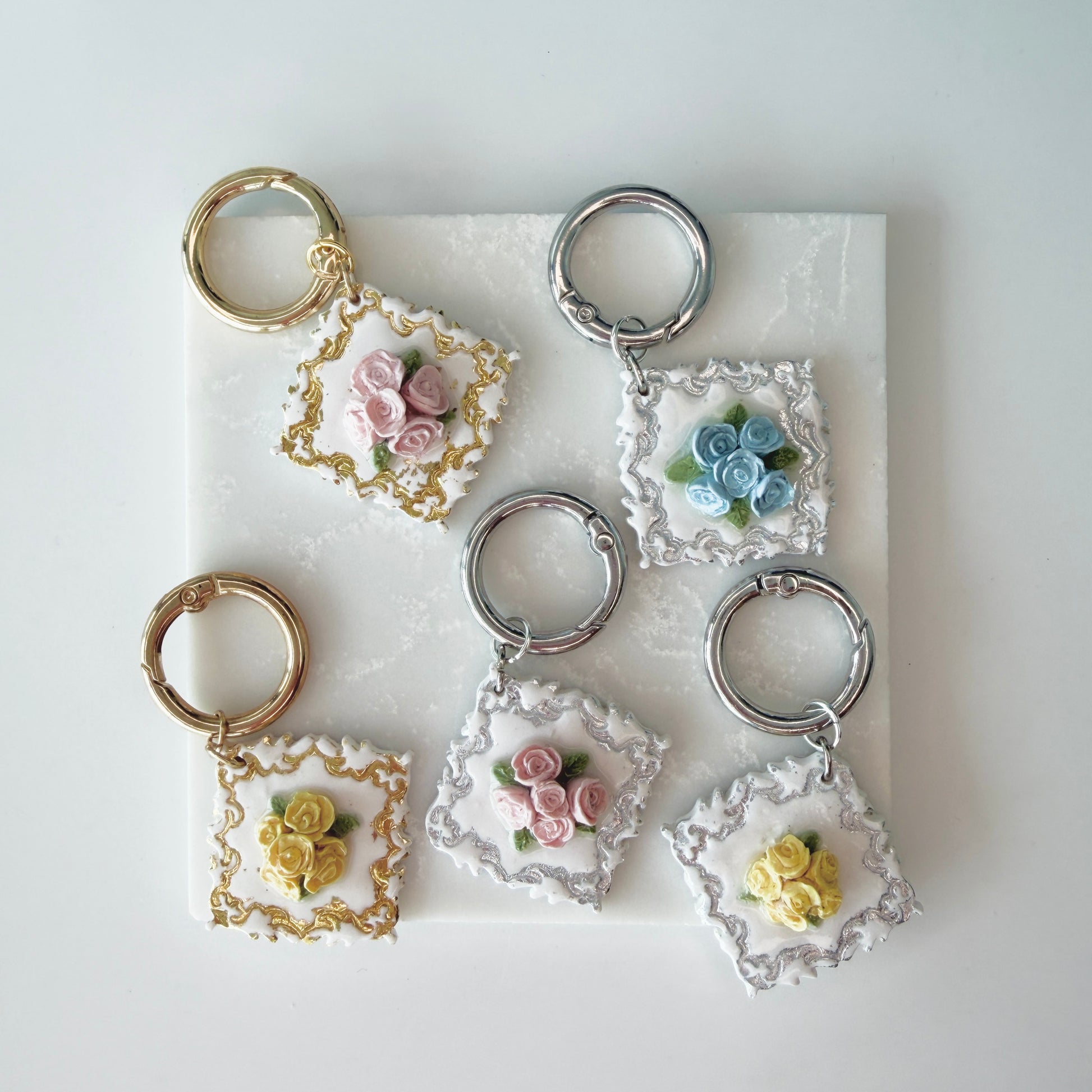 Set of pet id tags with floral designs on a marble surface
