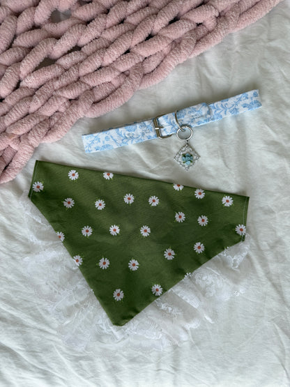 Dog collar with floral pattern and green bandana with white floral pattern on a textured surface.