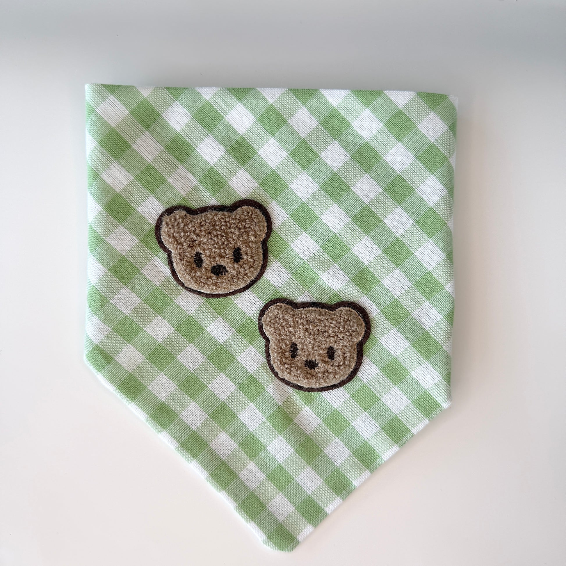 Green and white checkered bandana with two brown bear faces on a white background