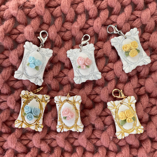 Decorative pendants with floral designs on a textured pink fabric background