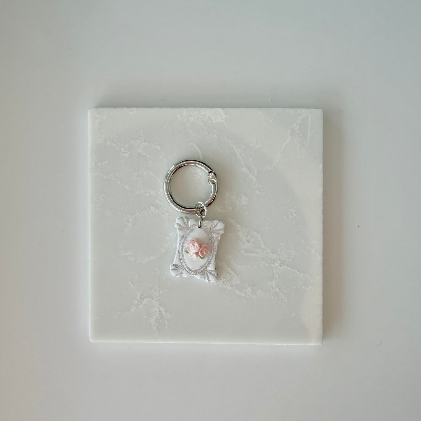 Rectangle pet id tag with 3 pink roses and silver engraving on a white marble background