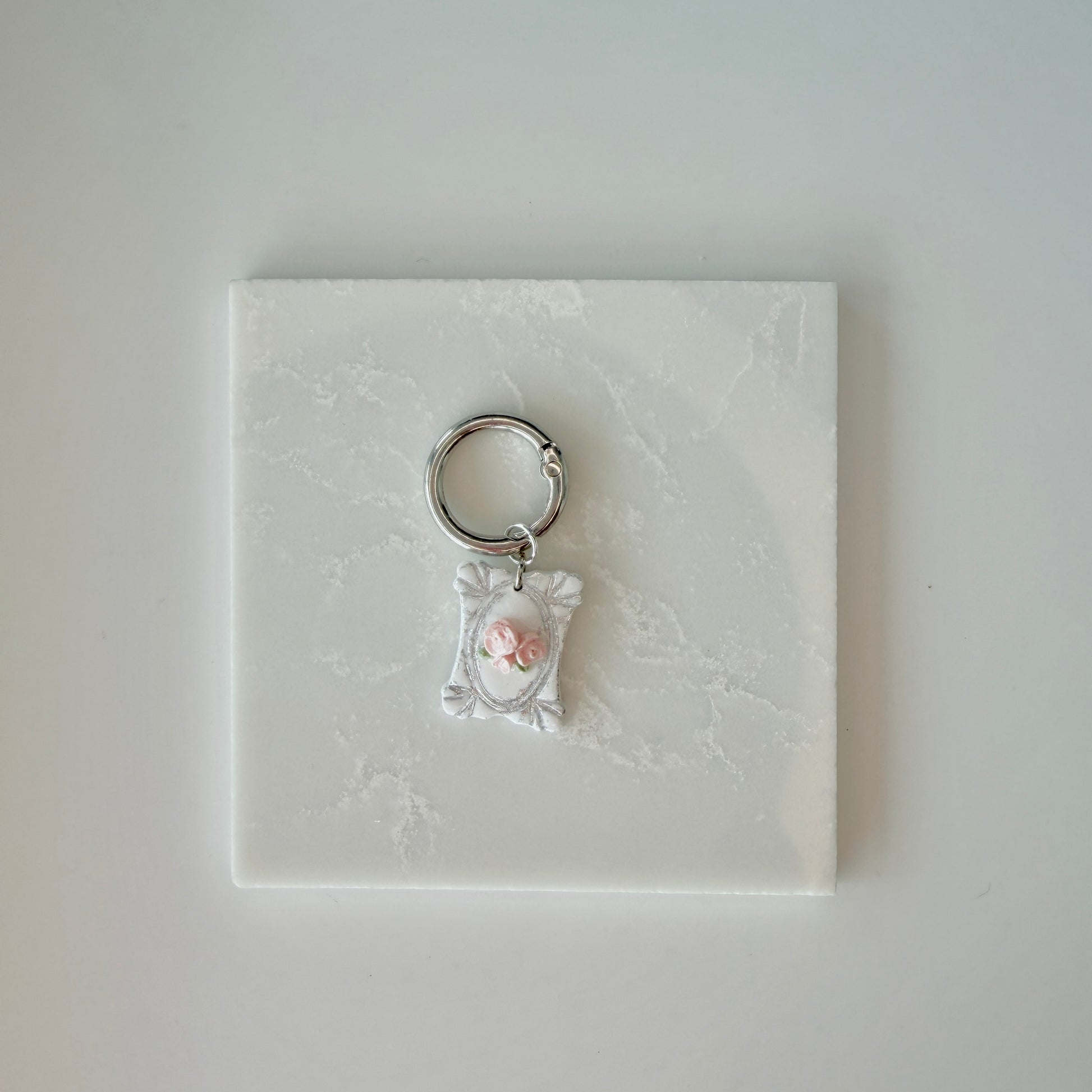Rectangle pet id tag with 3 pink roses and silver engraving on a white marble background
