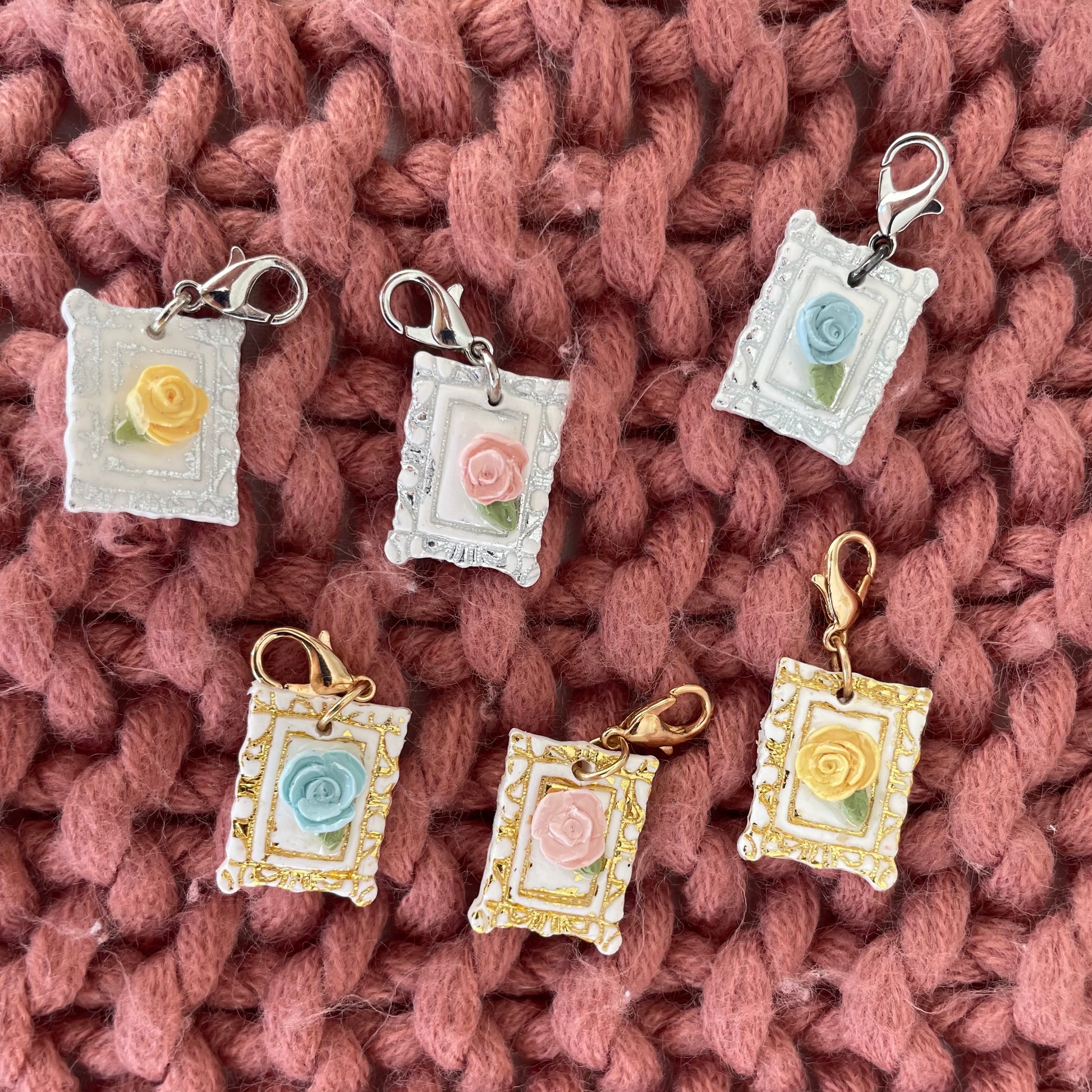 Decorative charms with floral designs on a knitted fabric background