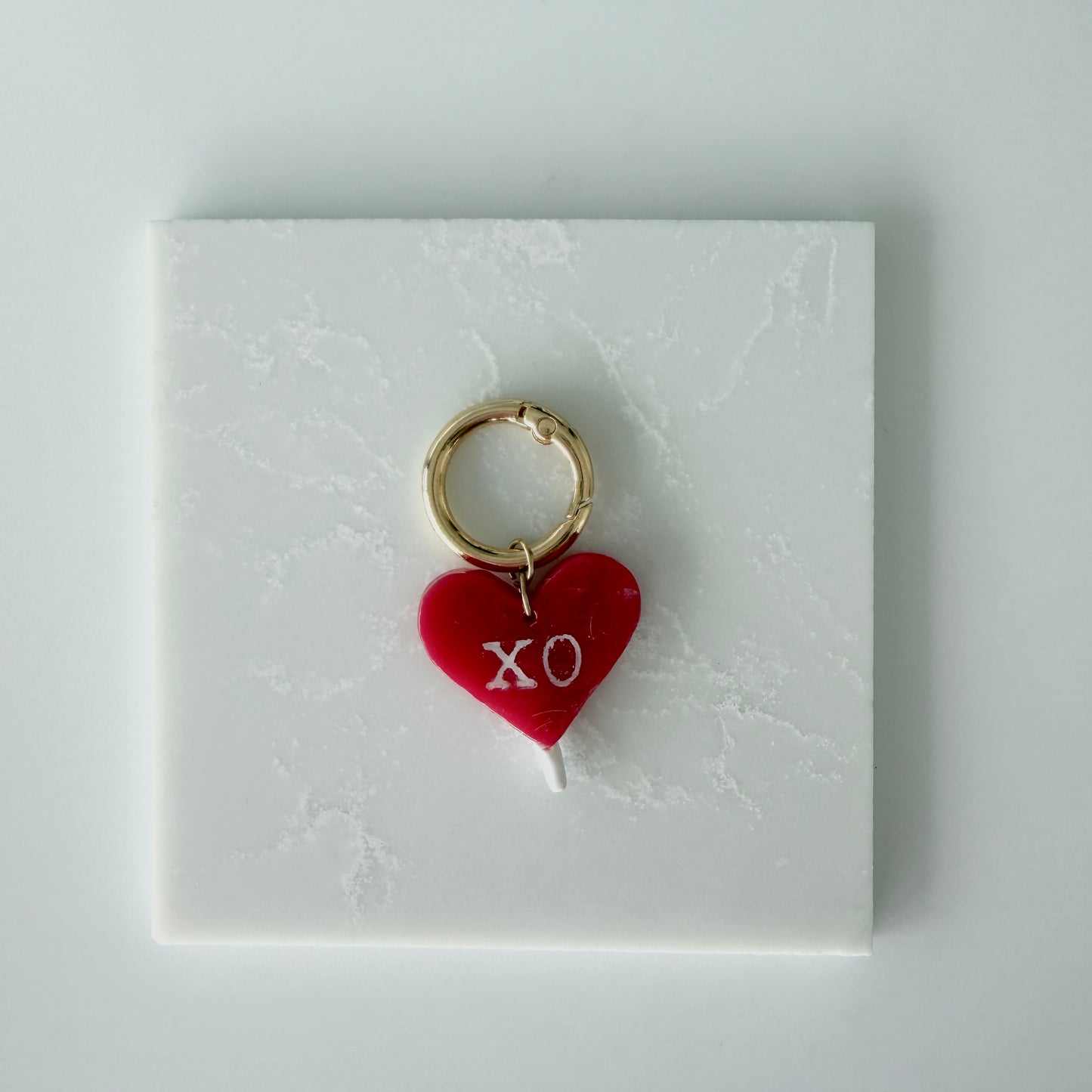 red heart charm on a white card