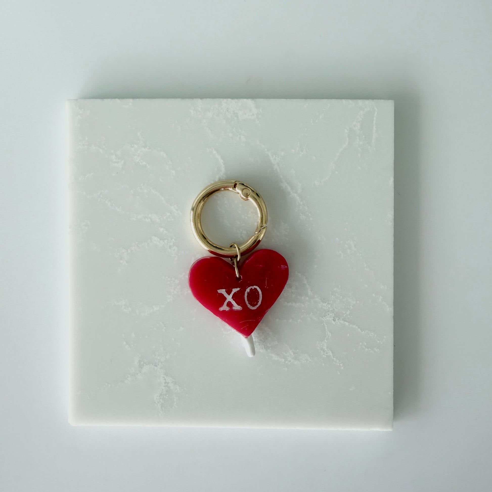 red heart charm on a white card