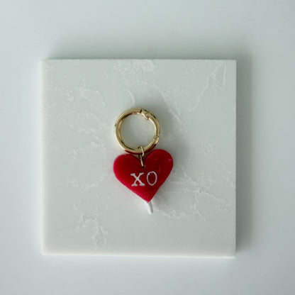 red heart charm on a white card