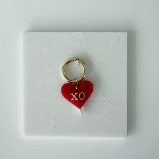 red heart charm on a white card